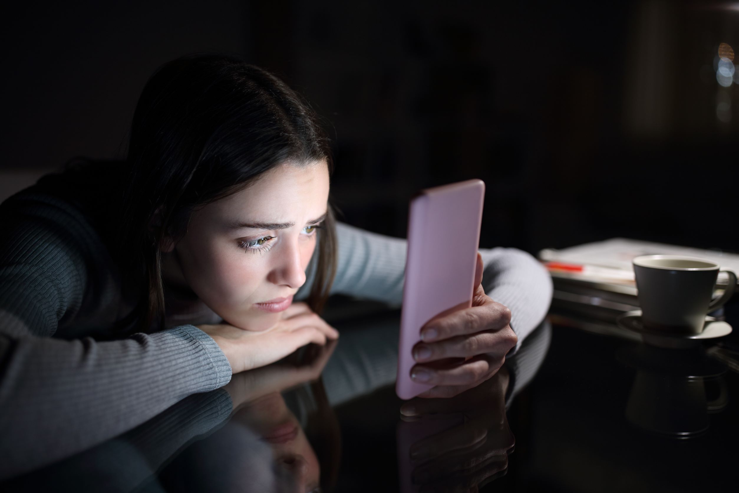 girl looking at phone in dark